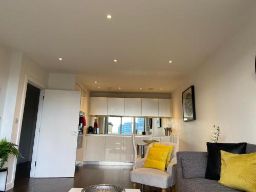 a living room with a couch and a kitchen at Blissful One Bed Near The River in Kew Bridge
