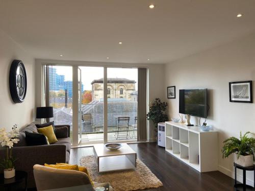 a living room with a couch and a tv at Blissful One Bed Near The River in Kew Bridge