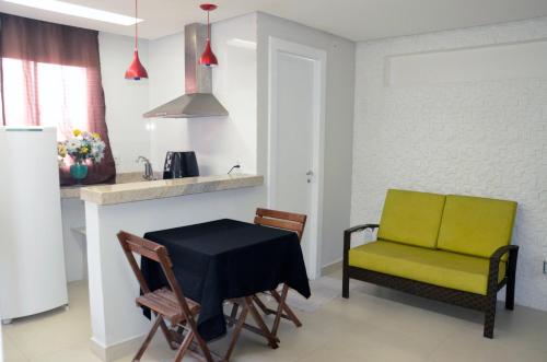 a kitchen and dining room with a table and chairs at Vila Suítes Coliving in Vila Velha