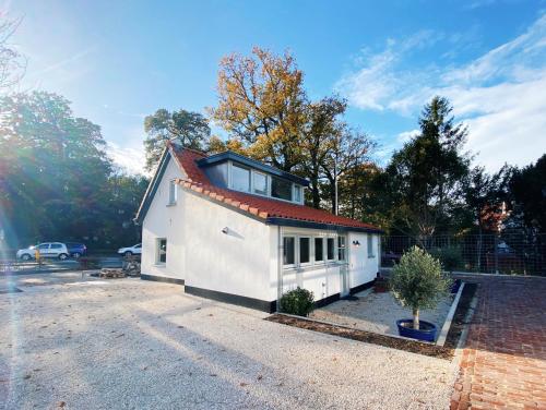 a white house with a red roof at Cozy historical Cottage (Huisje HèHè) in Wassenaar