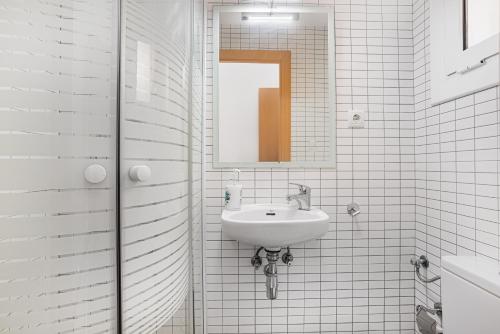 a white bathroom with a sink and a mirror at Holiday home Splendid Park Güell in Barcelona