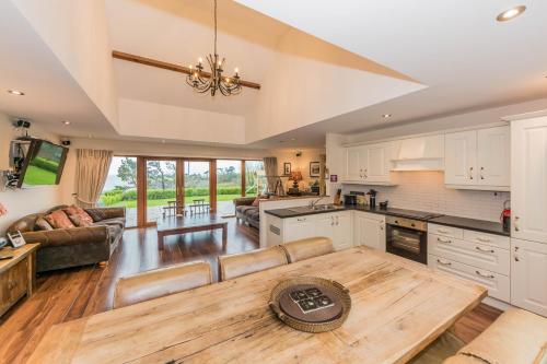 eine offene Küche und ein Wohnzimmer mit einem Tisch in der Unterkunft Ardkilly Ridge, Kinsale Town,Sleeps 8 in Kinsale