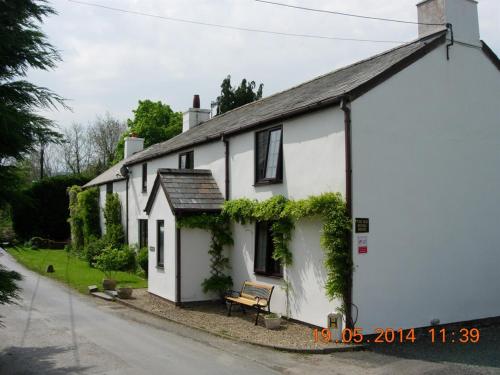 a white house with ivy on the side of it at The Old School House Bed and Breakfast in Llanbrynmair