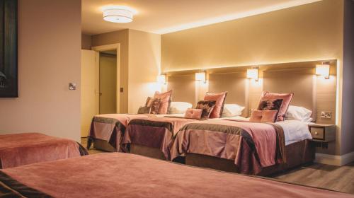 a hotel room with two beds and two lamps at Barr Na Sraide Inn in Dingle