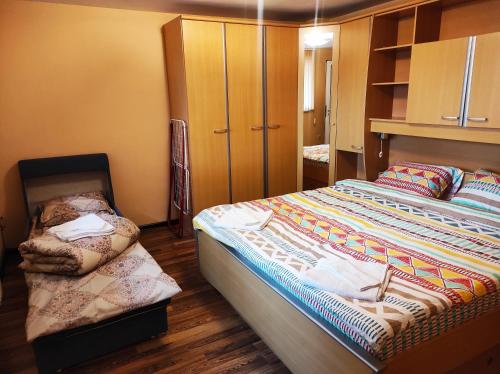 a bedroom with a bed and a chair in it at Pavlovi Apartments in Samokov