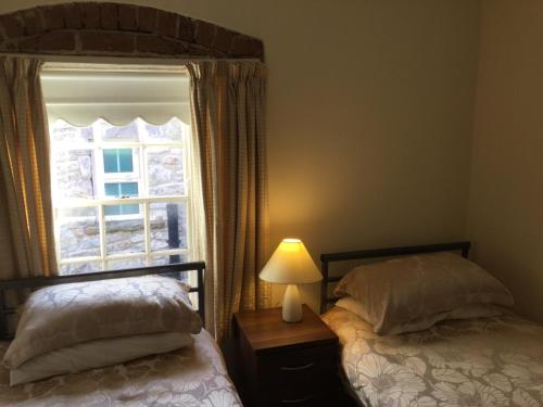 a bedroom with two beds and a window at Coach house in Armagh