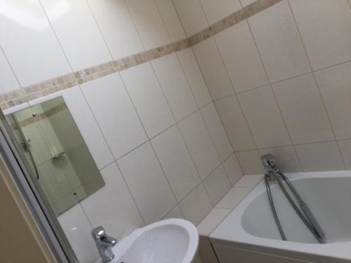 a bathroom with a toilet and a tub and a sink at Dobbin Lodge in Armagh