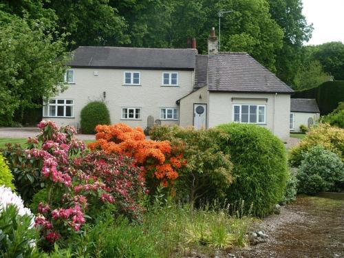 uma casa com um ramo de flores à frente dela em The Coach House em Milford