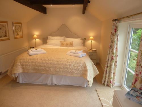 a bedroom with a bed with two towels on it at The Coach House in Milford