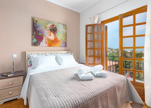 a bedroom with a bed with a painting on the wall at Villa Artemida Vravrona in Vravrona