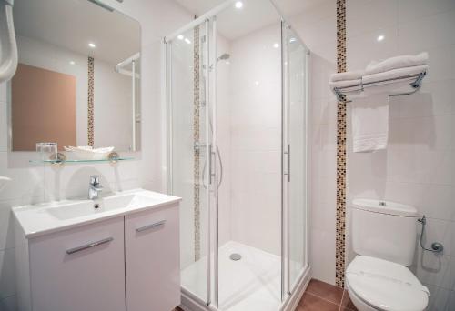 a white bathroom with a toilet and a shower at Promotel in Carros