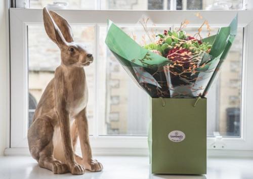 a statue of a rabbit next to a box of flowers at The Saddle Room in Middleham