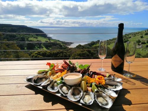 a plate of oysters on a table with a bottle of wine at Sea Dragon Kangaroo Island in Penneshaw