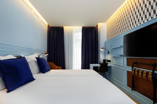 a bedroom with a large bed and a television at Mercure Porto Centro Aliados in Porto