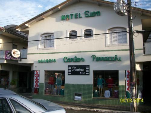 a white building with a store front with windows at Hotel Sion in Monte Sião