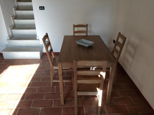 a wooden table and chairs in a room with stairs at Central Lovely House in Montepulciano