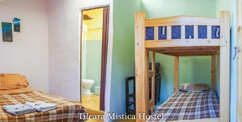 1 dormitorio con litera y espejo en Tilcara Mistica Hostel en Tilcara
