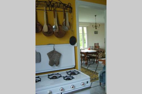 une cuisine avec une cuisinière et quelques casseroles et poêles dans l'établissement Ferme de Wichery, Gite 2-6 pers., à Rozoy-sur-Serre