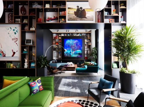 a living room with a green couch and a tv at citizenM Seattle South Lake Union in Seattle