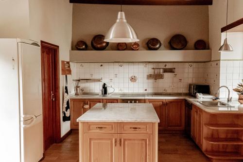cocina con armarios de madera y encimera blanca en Casa Los Lirios, en Santa Brígida