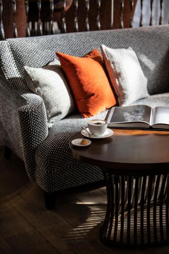 a coffee table with a laptop on a couch with pillows at One Aldwych in London