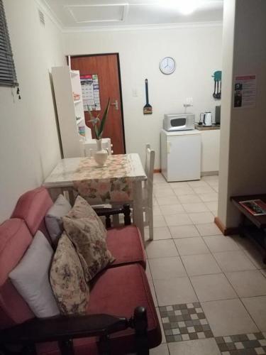 a living room with a couch and a table at Garden Route Stay in George