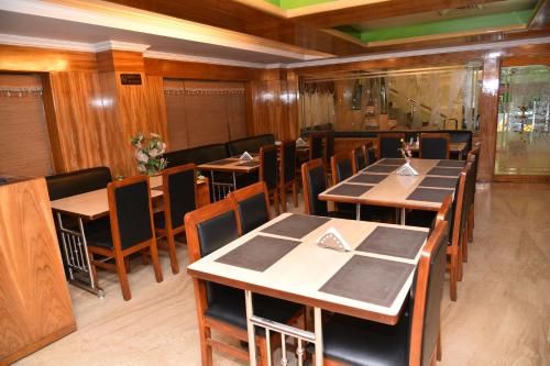 a dining room with wooden tables and chairs at Hotel Sonas in Tiruchchirāppalli