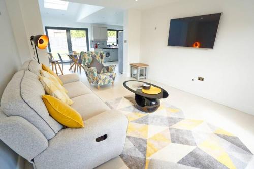 a living room with a couch and a table at Home from home - 4 Double Bed House with Parking in Slough