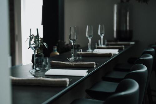 a row of tables with wine glasses and chairs at HOTEL 101 KANAZAWA in Kanazawa
