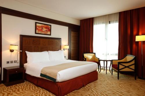 Habitación de hotel con cama y mesa en Holiday Inn Olaya, an IHG Hotel, en Riad