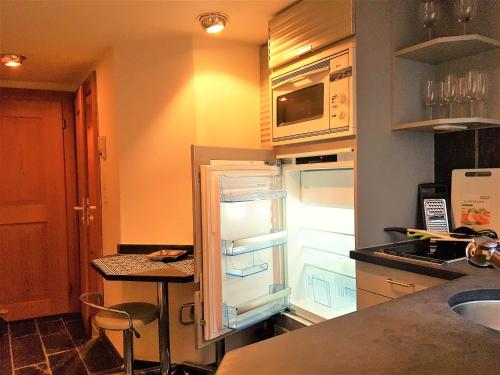 eine Küche mit offenem Kühlschrank in der Unterkunft Swiss Chalet Style in Zürich