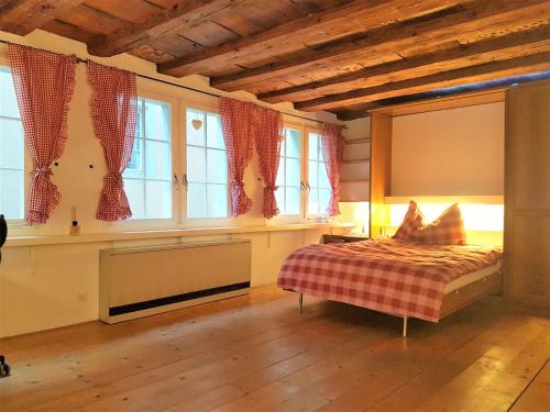 um quarto com uma cama num quarto com janelas em Swiss Chalet Style em Zurique