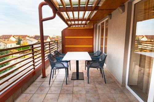 a balcony with a white table and chairs at Bella Mura Golden Apartment in Moravske-Toplice