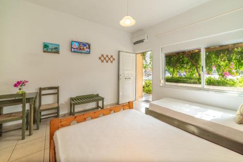 a bedroom with two beds and a table and a window at Akti Galinis in Kalyves