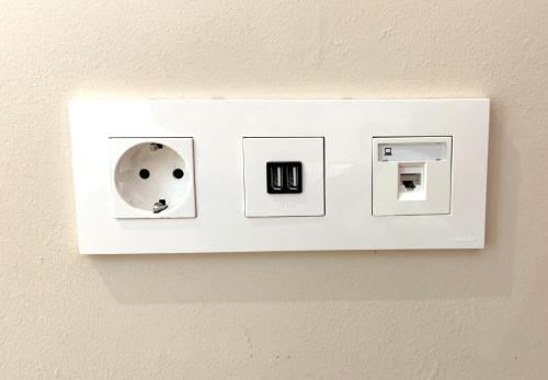 a white light switch on a wall at Sea to Sky Suites - Mijas Pueblo in Mijas