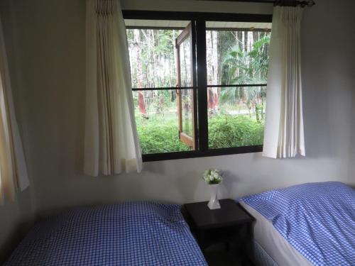 a bedroom with a bed and a window at Manora Garden in Phangnga