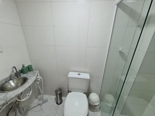 y baño con aseo, lavabo y ducha. en Apartamento na Av Atlantica com Ar Condicionado, en Balneário Camboriú