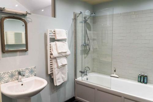 W łazience znajduje się umywalka, wanna i prysznic. w obiekcie T's at Lower Rudloe Farm w mieście Corsham