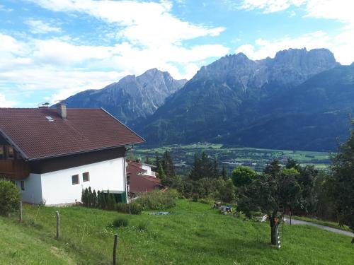 Ferienhaus Weixelbraun في Iselsberg: منزل على تلة مع جبال في الخلفية