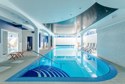 Villa Hoff Wellness & Spa في تسيساكز: مسبح كبير في غرفة كبيرة