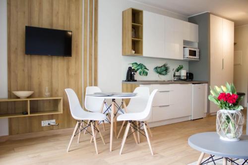 kuchnia i salon ze stołem i krzesłami w obiekcie Apartament - studio Wisła z widokiem na góry w Wiśle