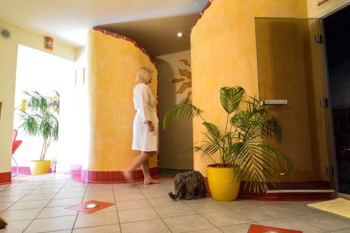 a woman in a white dress walking down a hallway at Hotel Garni Erlbacher in Schladming