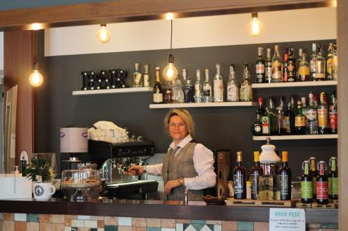 a woman is standing behind a counter in a bar at Terme Villa Pace in Abano Terme