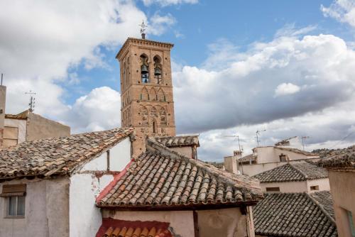 een hoge toren met een klok bovenop een gebouw bij La Casa de Jabe - Toledo Casco Antiguo in Toledo