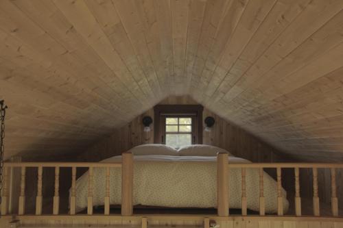 Cama en habitación con techo de madera en Domaine Floravie, en Le Bic