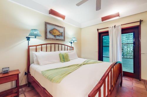 Un dormitorio con una cama grande y una ventana en Beachside Villas Gold Standard Certified en Placencia Village