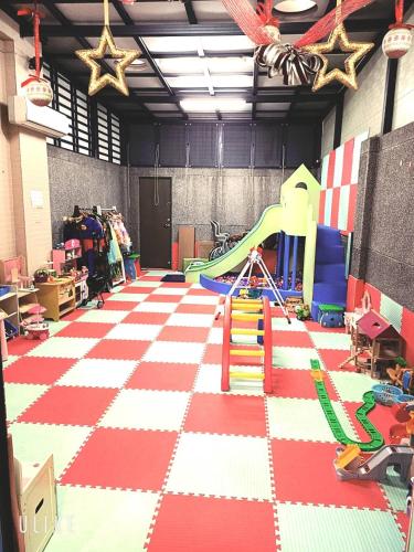 a room with a play area with a slide at Funny Eggs Guest House in Tainan