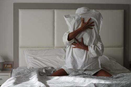アーバノ・テルメにあるテルメ ヴィラ ペースの毛布を被ったベッドに腰掛けた女性