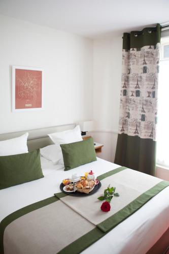 a bed with a tray of food on it at Hotel La Manufacture in Paris