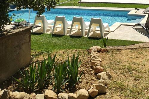 un jardin avec des chaises et une piscine dans l'établissement Belle longère au calme - L'auguste maison d'hôtes, à Valensole